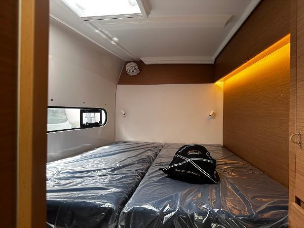 2024 Excess 11 interior cabin with twin beds, modern lighting, and sleek design.