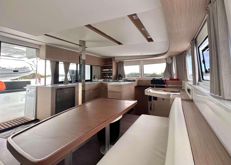 Interior of 2023 Lagoon 46 catamaran, featuring modern kitchen and dining area.
