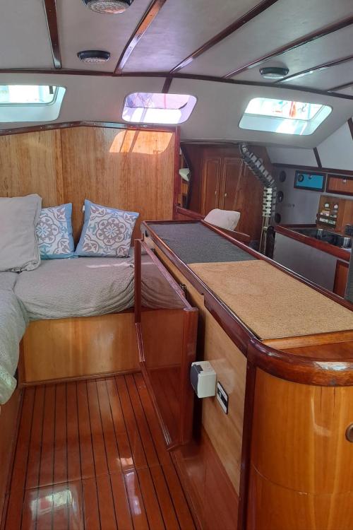 Luxurious interior of 2019 Custom Patago 40 yacht with wood finish and cozy bedding.