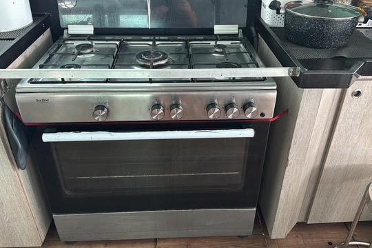 Stainless steel stove with multiple burners and oven, Etoile Marine Maxi Cat 24, 2004 model.