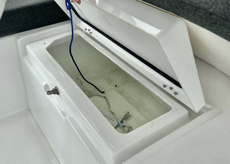 Open storage compartment on 2023 Lagoon 46 yacht, featuring a white interior and wiring.