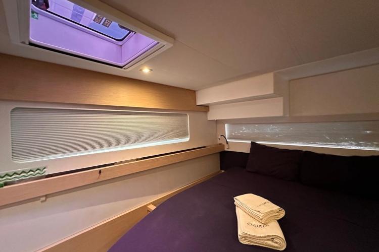 Luxurious cabin interior of 2016 Fountaine Pajot Ipanema 58 yacht with skylight and cozy bedding.