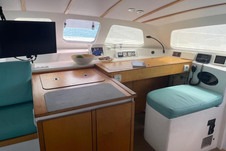 Interior of 2010 Custom KSENIA 149 boat with wooden cabinetry and teal seating.