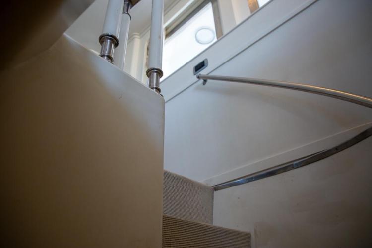 Staircase inside a 1972 Benetti 33 yacht, featuring sleek metal railings.
