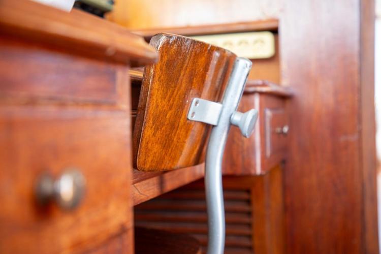 Vintage wooden interior of 1972 Benetti 33 yacht, featuring a classic chair and desk.