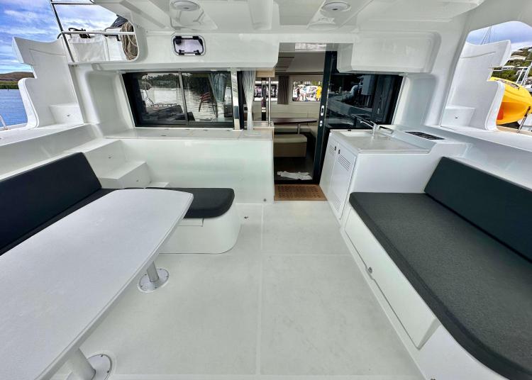 2023 Lagoon 46 yacht interior with modern seating and dining area.