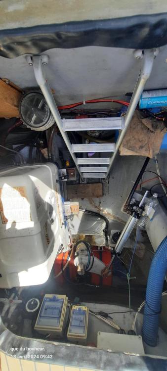 Engine room of Custom KSENIA 149 boat, featuring ladder and various mechanical components.