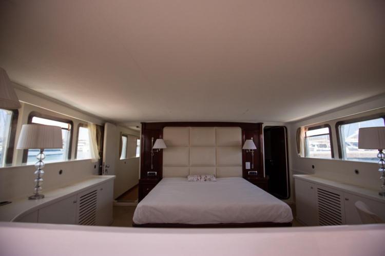 Luxurious bedroom interior of 1972 Benetti 33 yacht with elegant decor and ample natural light.