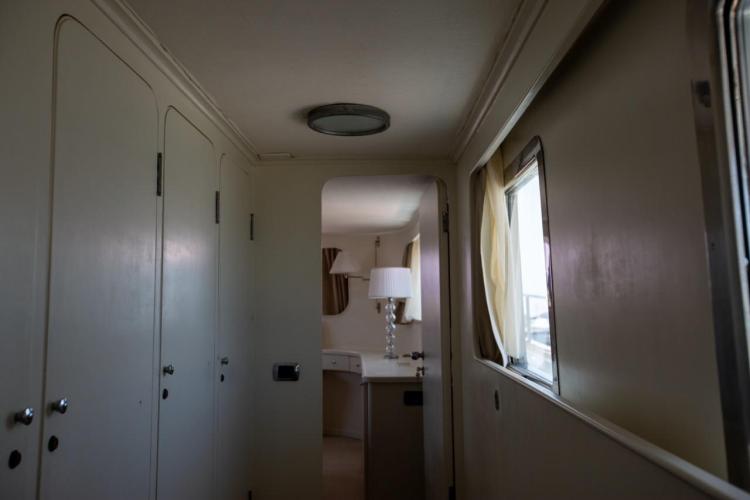 Interior hallway of a 1972 Benetti 33 yacht, featuring doors and a window with curtains.