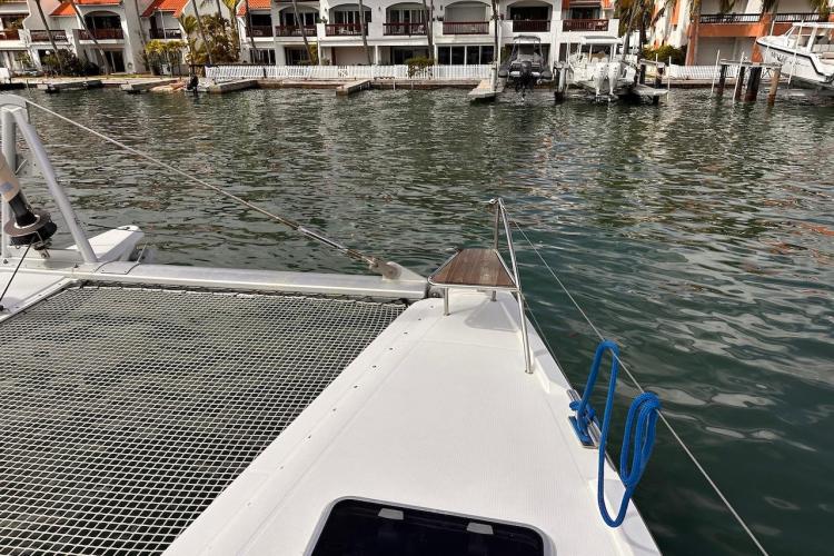 2016 Fountaine Pajot Ipanema 58 catamaran docked near waterfront homes.