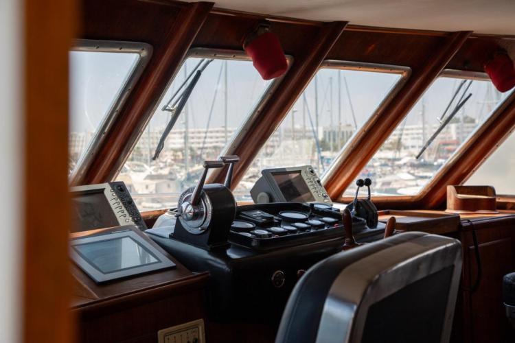 Interior view of 1972 Benetti 33 yacht cockpit with navigation equipment and marina view.
