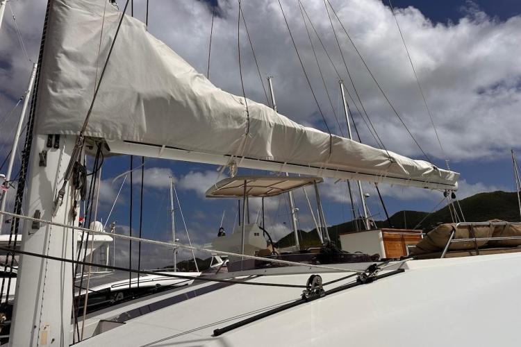 2016 Fountaine Pajot Ipanema 58 catamaran with sails furled, under a partly cloudy sky.