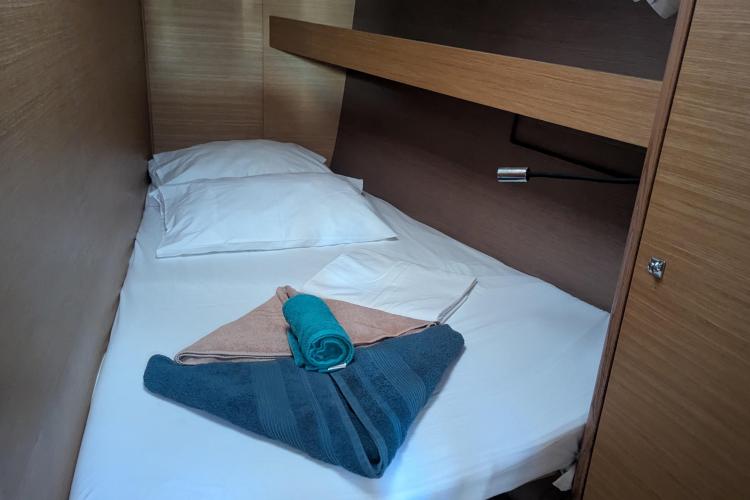 Cozy cabin bed in 2017 Dufour 460 Grand Large yacht with neatly arranged towels.