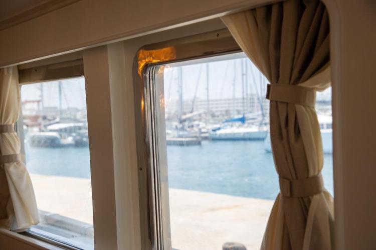 View from Benetti 33 yacht window, showcasing marina with docked boats, 1972 model.