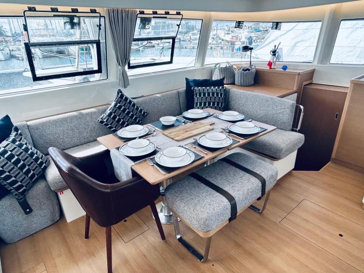 Luxurious 2024 Excess 14 yacht interior with elegant dining setup and modern decor.