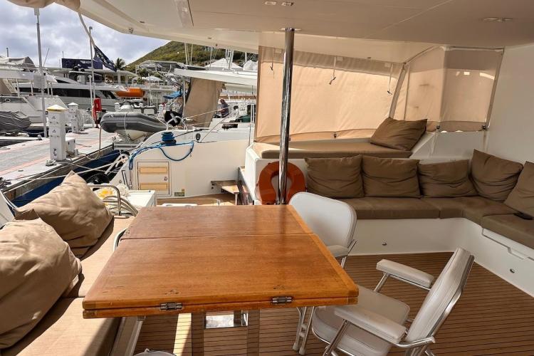 Luxurious 2016 Fountaine Pajot Ipanema 58 yacht interior with seating and table in marina.