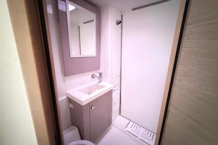 Modern bathroom interior on 2020 Fountaine Pajot Astrea 42 catamaran, featuring sleek sink and mirror.