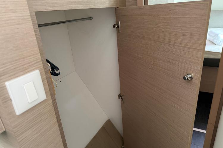 Open wooden closet on Fountaine Pajot Astrea 42 yacht, showcasing interior storage space.