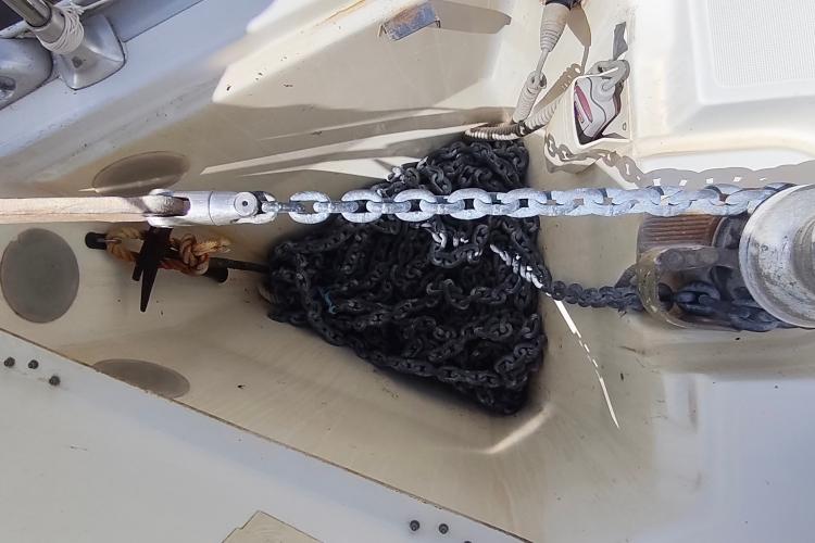 Anchor chain and winch on a 2000 Jeanneau Sun Odyssey 37 sailboat deck.