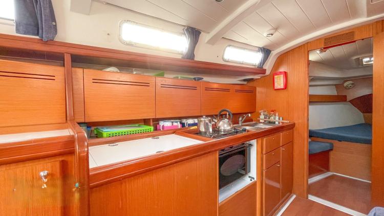 Interior of 2005 Beneteau Cyclades 43.3 yacht, featuring a wooden kitchen and cozy cabin.