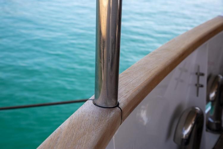 Close-up of Benetti 33 yacht railing, 1972 model, with turquoise water background.