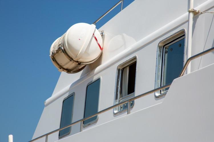 1972 Benetti 33 yacht with lifeboat and windows against clear blue sky.