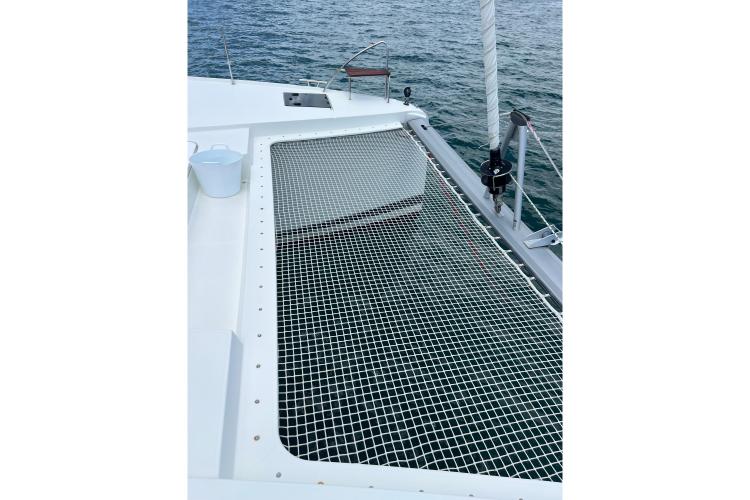 2023 Fountaine Pajot Astrea 42 Catamaran with netted deck over water.