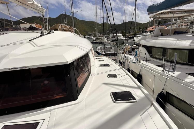 2016 Fountaine Pajot Ipanema 58 catamaran docked in a marina, surrounded by other boats.