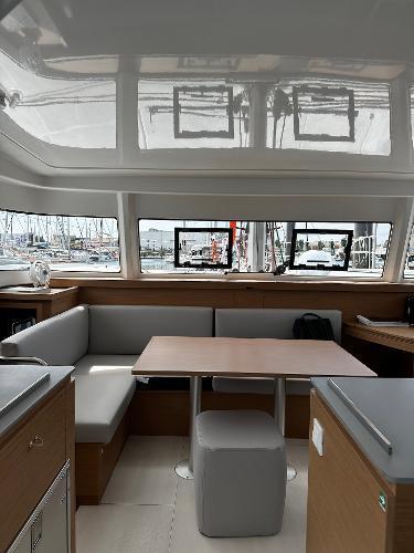 2024 Excess 11 yacht interior with modern seating and dining area, featuring large windows and sleek design.