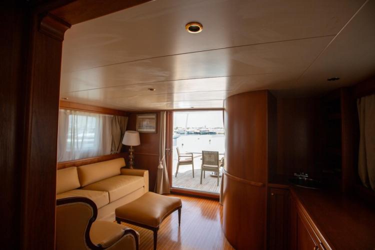 Luxurious interior of 1972 Benetti 33 yacht with elegant seating and marina view.