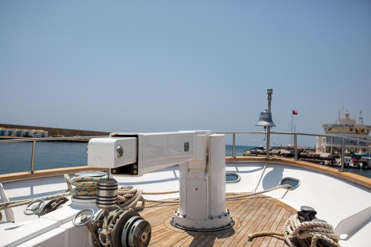 Bow view of 1972 Benetti 33 yacht with ropes and bell in harbor.