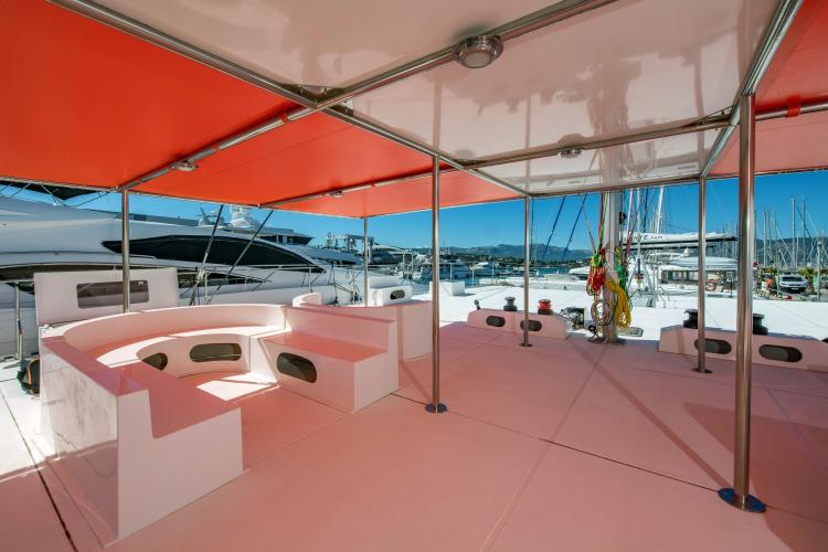 Spacious deck of 2026 Custom DAYCHARTER yacht with seating and vibrant canopy.
