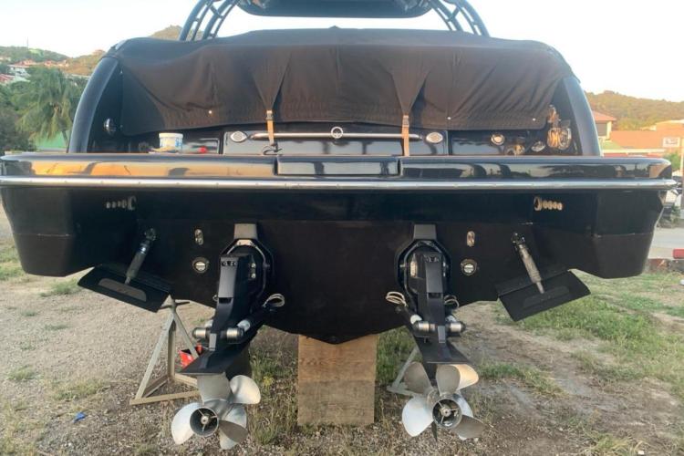 2018 Formula 350 Crossover Bowrider, rear view with dual propellers, on a stand outdoors.