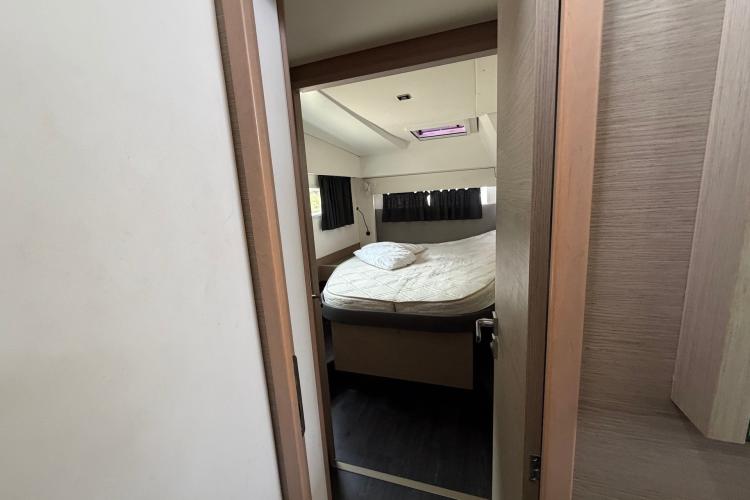 Interior cabin view of a 2020 Fountaine Pajot Astrea 42 catamaran, featuring a cozy bed.