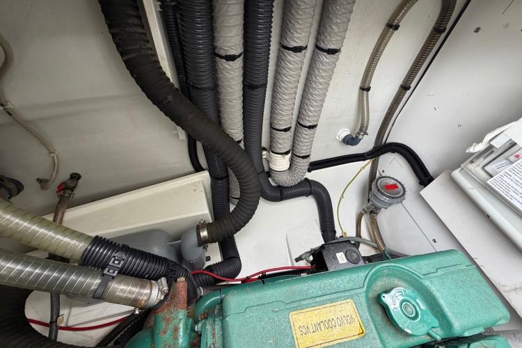 Engine compartment of 2020 Fountaine Pajot Astrea 42, showcasing hoses and mechanical components.
