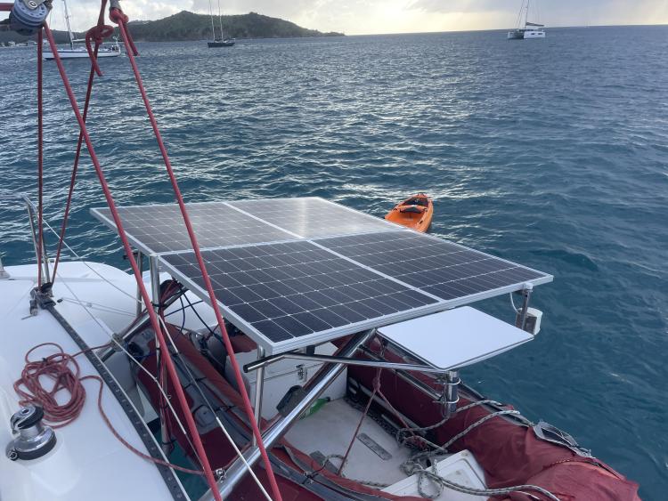 Solar panels on a 2006 Fountaine Pajot Bahia 46 catamaran, anchored in a scenic bay.