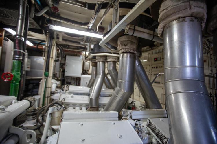 Engine room of a 1972 Benetti 33 yacht with complex piping and machinery.