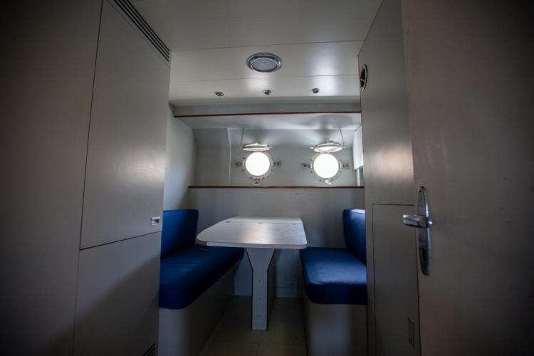 Interior of 1972 Benetti 33 yacht with cozy dining area and porthole windows.