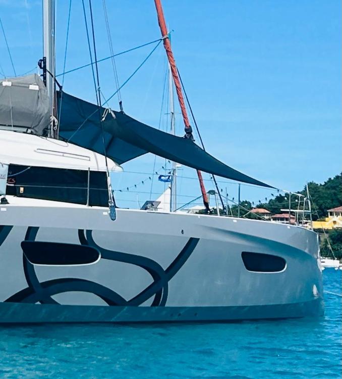 2024 Excess 14 catamaran with modern design, anchored in clear blue waters.