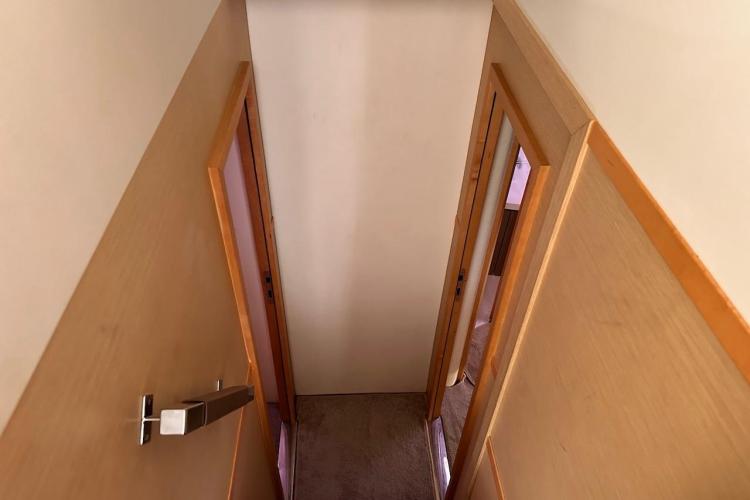 Narrow hallway inside 2016 Fountaine Pajot Ipanema 58 yacht with wooden doors.