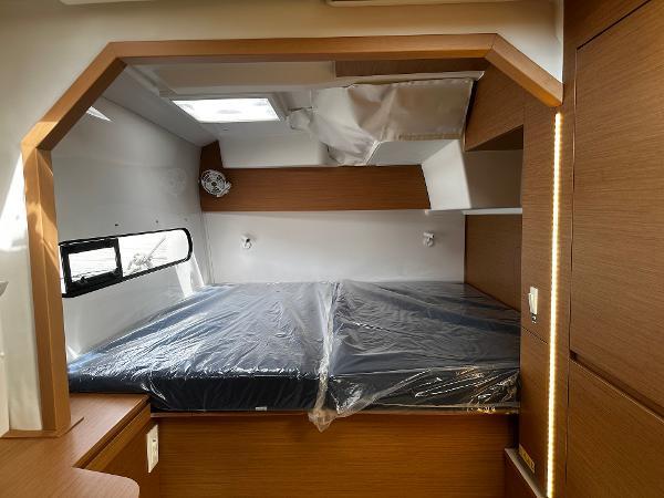 2024 Excess 11 interior cabin with bed, skylight, and wooden accents.