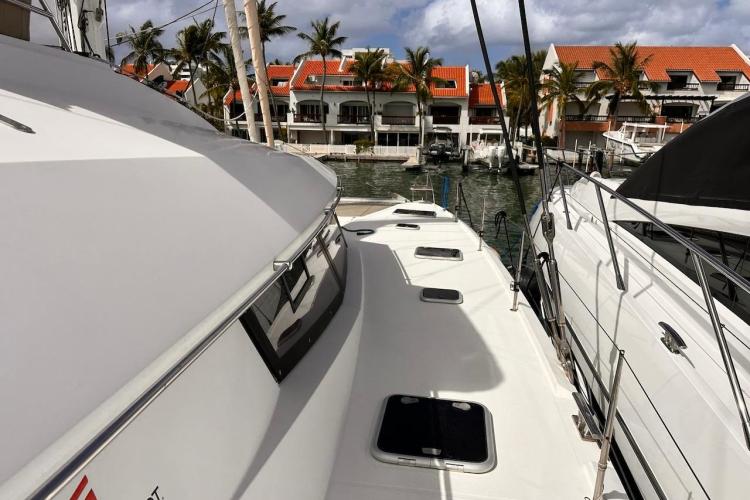 2016 Fountaine Pajot Ipanema 58 catamaran docked near waterfront homes.