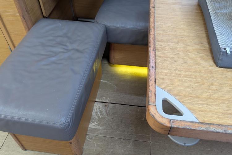 Interior of 2017 Dufour 460 Grand Large yacht with wooden table and cushioned seating.