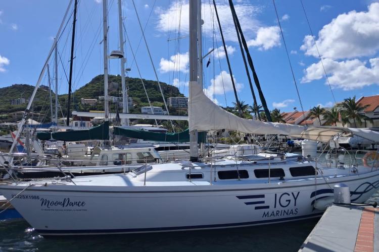 1986 Dufour CATALINA sailboat docked at IGY Marinas under a clear blue sky.