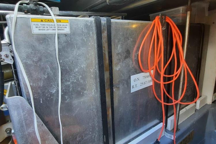 Engine room of 2000 Carver 530 Voyager Pilothouse with fuel tank and cables.