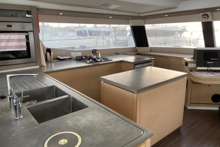 Modern kitchen interior of 2017 Fountaine Pajot SABA 50 catamaran with sleek countertops and appliances.