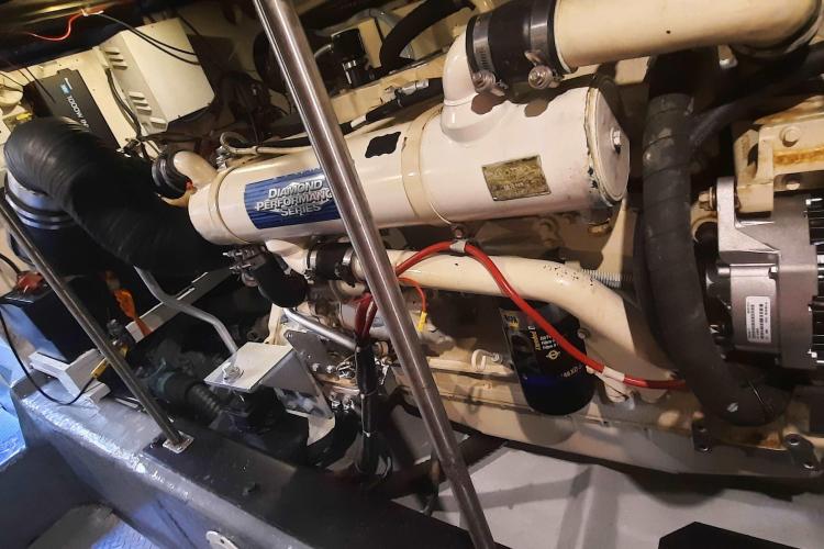 Engine room of 2000 Carver 530 Voyager Pilothouse, showcasing mechanical components and wiring.