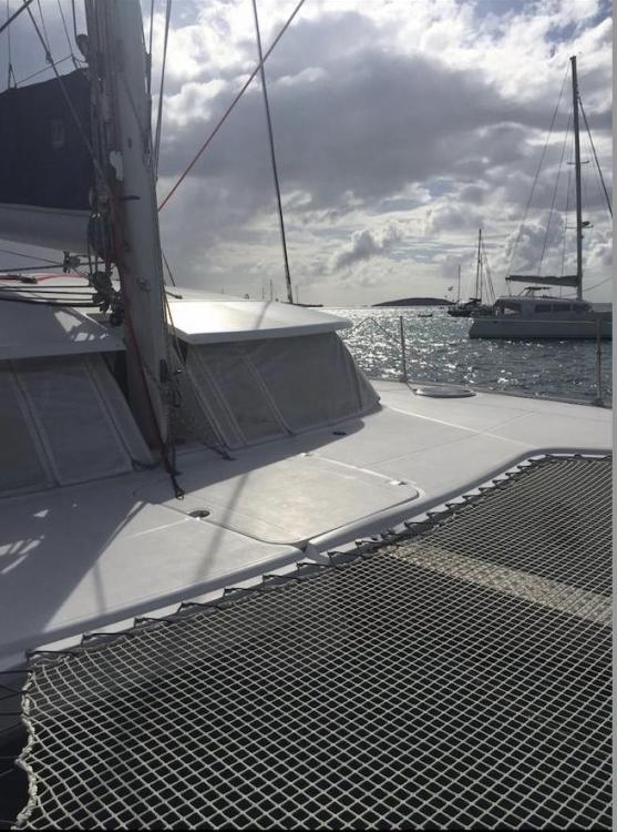 2009 Fountaine Pajot Orana 44 catamaran on water, cloudy sky, and distant sailboats.