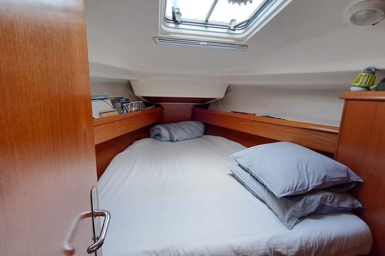 Cozy cabin interior of 2000 Jeanneau Sun Odyssey 37 sailboat with skylight and wooden finish.