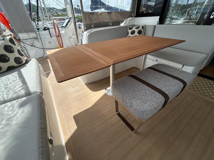 Luxurious interior of 2024 Excess 14 yacht with elegant wooden table and comfortable seating.
